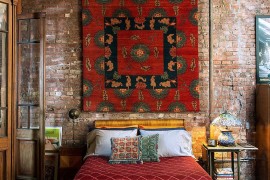 Bright and beautiful Tibetan rug on the wall of the eclectic bedroom in New York home