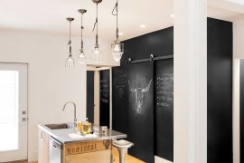 Chalkboard wall in the kitchen along with a tiny island clad in reclaimed wood