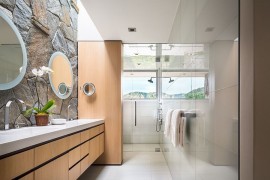 Contemporary bathroom combines glass tile with the classic stone wall