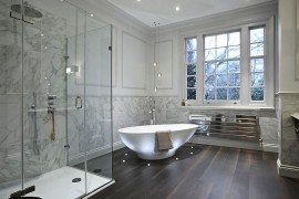 Contemporary bathroom in neutral hues with brilliant lighting around the bathtub