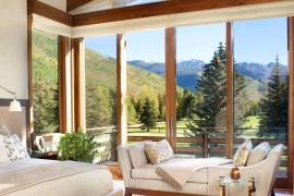 Corner windows of the bedroom with walnut trims open it up towards the mountain view outside