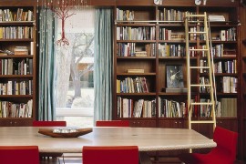 Custom chandelier and fabulous red chairs add color to the home library dining room