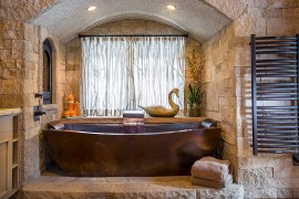 Custom copper bathtub and stone backdrop steal the show here