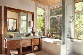 Custom vanity in the bathroom clad from walnut adds warmth to the setting