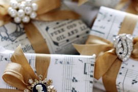 DIY wrapping paper using sheet music, gold ribbon, and jewelry pieces