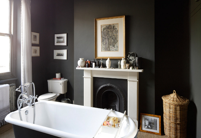 Dark walls and tub with a stunning black and white fireplace