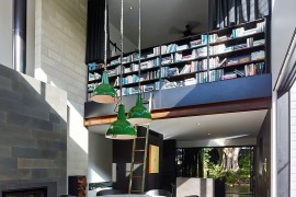 Double height dining room with a wall of books not for the faint of heart