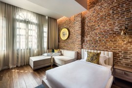 Exposed brick walls bring historic context to the refined, modern interiors of Loke Thyee Kee Residences