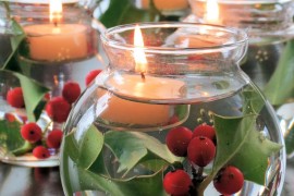 Glass bowls filled with water, holly, and floating candles