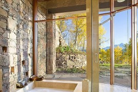 Gorgeous bathroom with natural stone wall and sunken tub