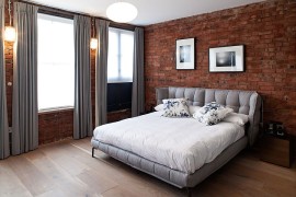 Gray brings contemporary elegance to the bedroom with exposed brick walls