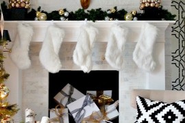 Holiday mantel with white stockings and gifts piled in fireplace