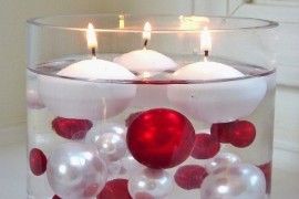 Large glass cylinder with Christmas ball ornaments and floating candles