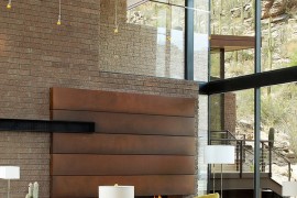 Large, open living space with tongue and groove ceiling finish connected with the outdoors