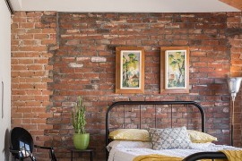 Louis Ghost Chair in the corner adds gloss to the industrial bedroom [From: Jason Roehner]