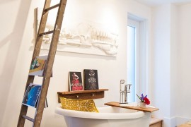 Salvaged wooden shelf, old ladder and vintage bathtub fashion an opulent and distinct bathroom