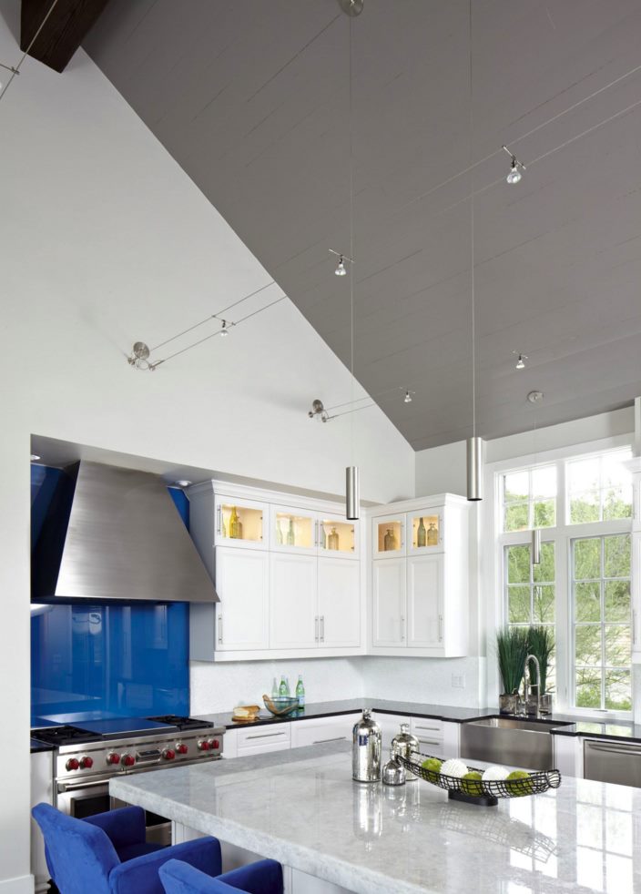 Small cylindrical pendants in a kitchen with blue accents