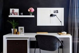 Small home workspace with a dark backdrop and sleek desk in white