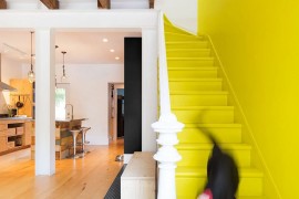 Staircase in yellow and penny tiled flooring delineate space inside the vivacious, remodeled row house