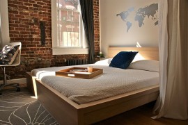 Unique modern bedroom design features wall decal and brick wall [Design: Beekman Lane]