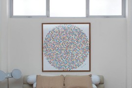 Wall art adds color to the small bedroom in white