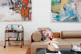 Wall art and accent pillows add color and pattern to the simple brick wall backdrop in white