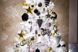 White Christmas all lit up with gold, black, and white ornaments