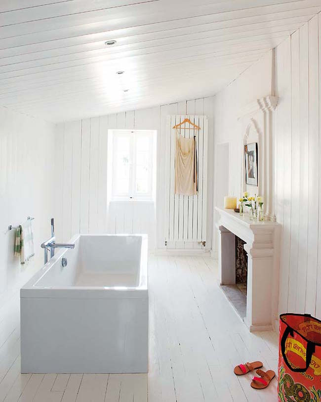 White bathroom and freestanding tub with fireplace