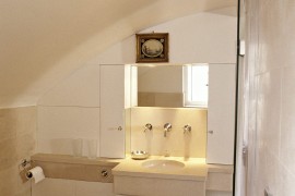 White bathroom with a wall-mounted spotlight