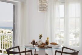 White cylindrical pendant light in a bright dining room