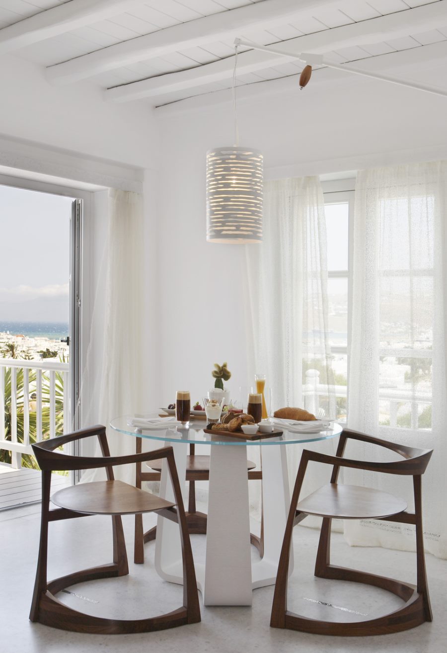 White cylindrical pendant light in a bright dining room