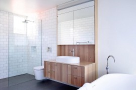 Wooden bathroom vanity unit brings textural variance to the all-white setting