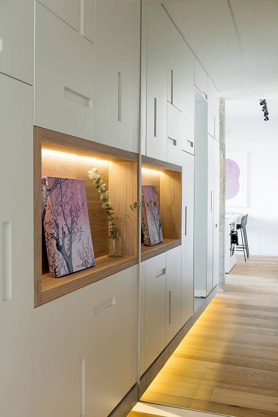 Wooden niches surrounded by bespoke cabinets at the entrance of the apartment