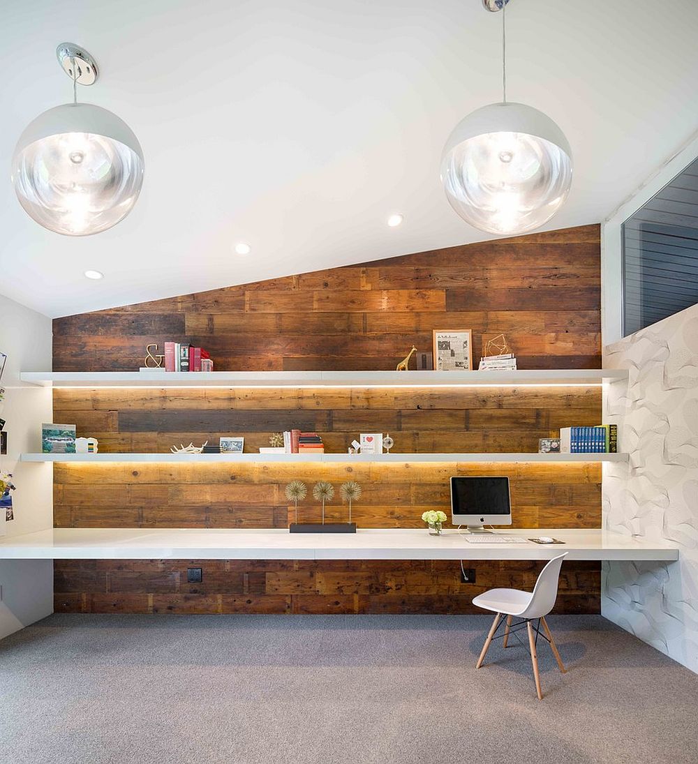Gorgeously lit shelves and reclaimed wood wall create a stunning midcentury modern home office