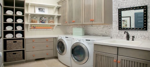 grey and orange laundry room with wooden cabinets for storage