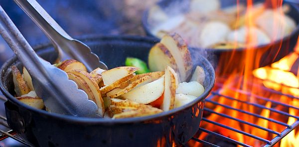 cooking food in the pan on the grill