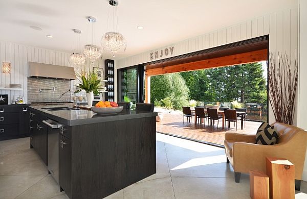 indoor - outdoor living area with black furniture and wooden deck