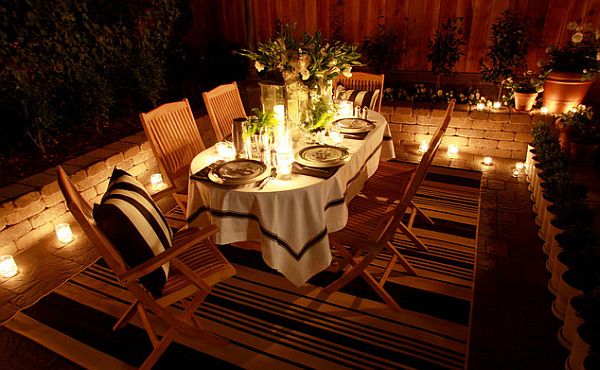 Outdoor dining table decor with candles and fancy rug