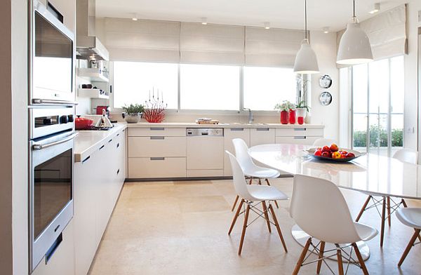 White kitchen with oval shaped table and eames chairs