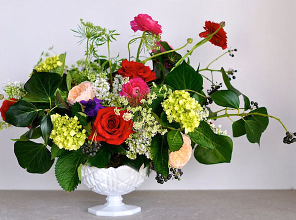 ranunculus flower arrangement in a milk glass vase