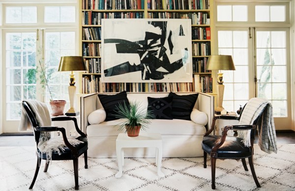 Artwork hangs over a living room bookshelf