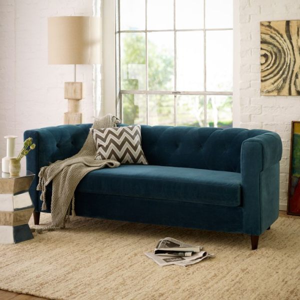 A deep blue sofa in a white living room