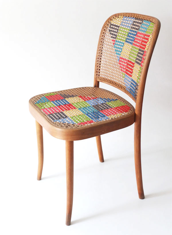 A cross stitched cane chair