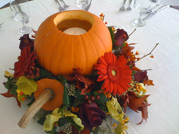 A fall centerpiece with flowers and a pumpkin