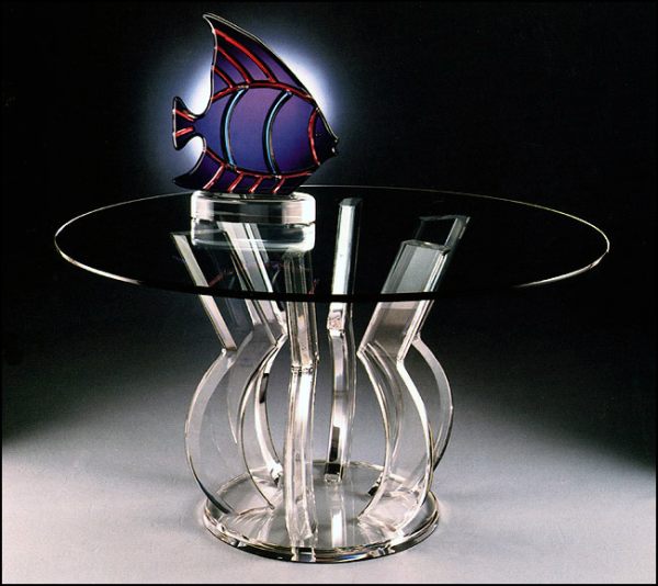 A round acrylic dining table with an interesting base