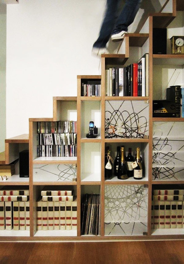 Diversely decorated shelves hidden away by the stairs