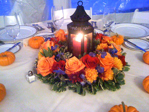 Fresh flowers and a lantern in an autumn centerpiece