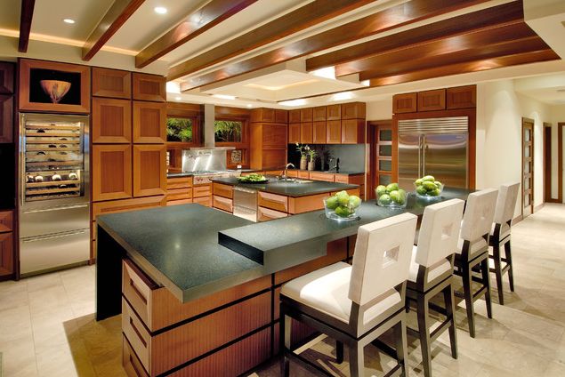 Modern wooden kitchen with chairs at the eat in counter and wine fridge