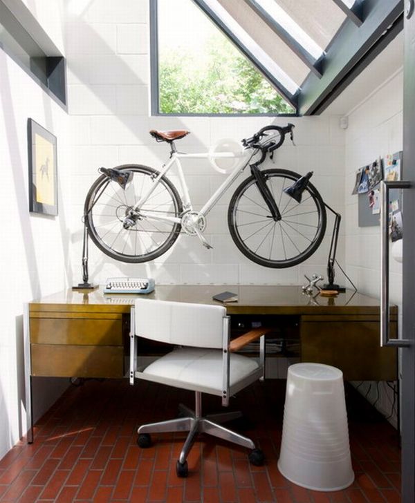 Space-conscious-home-office-with-sloped-windows-and-a-bicycle-mounted-on-the-wall