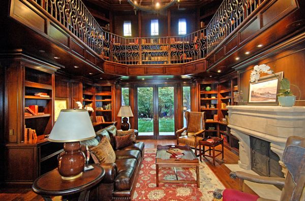 Two story home office library with hand carved limestone fireplace